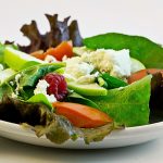 Gebackener Ziegenkäse im Speckmantel auf fruchtigem Salat mit Honig-Senf-Vinaigrette